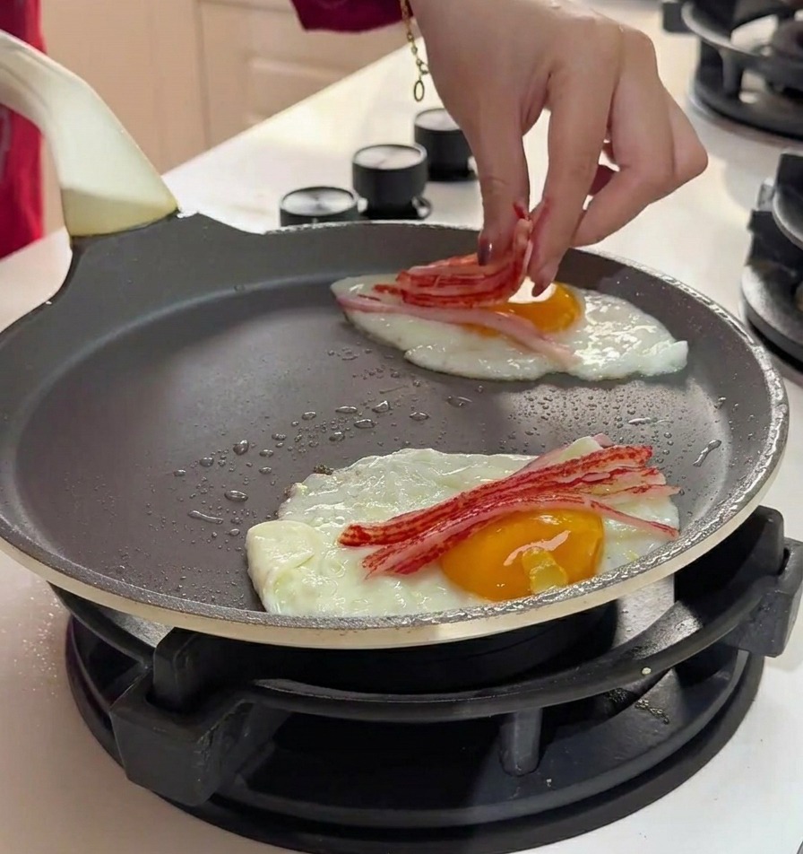 팬에서 익어가는 계란 위에 결대로 찢은 게맛살을 올리는 손