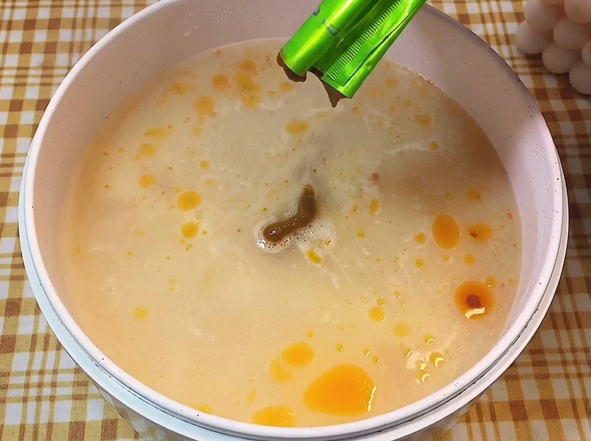 끓는 물에 액상 스프를 짜 넣어 뽀얀 국물을 만드는 장면.