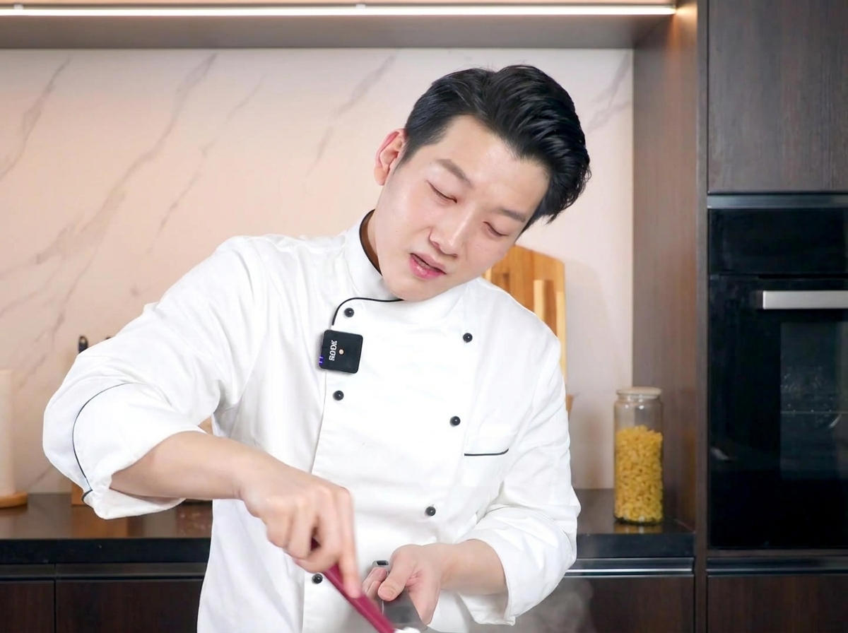 주걱으로 면과 계란 소스를 빠르게 섞는 모습.