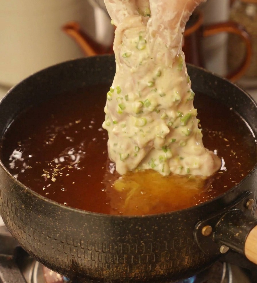 대파 반죽을 입힌 닭고기를 달궈진 기름 솥에 조심스럽게 넣는 모습