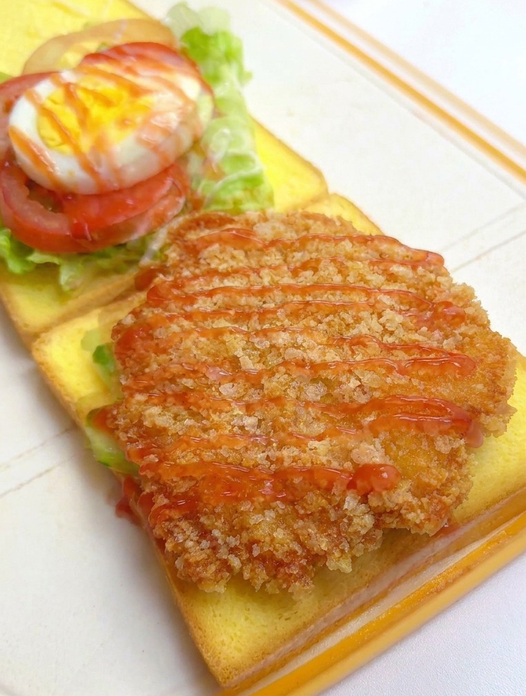 치킨 필레 위에 빨간 케첩을 뿌리는 모습
