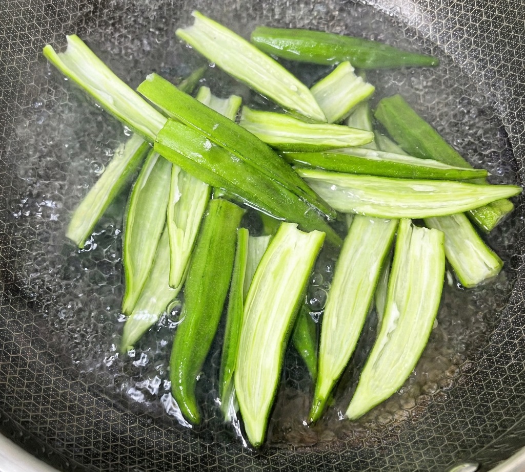끓는 물이 담긴 냄비에 손질한 오크라를 넣고 데치는 모습.