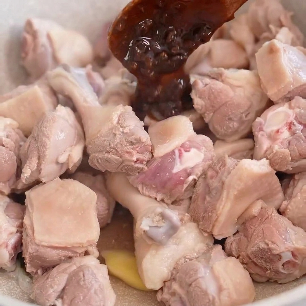 팬에 담긴 오리고기에 된장을 넣고 섞는 모습.