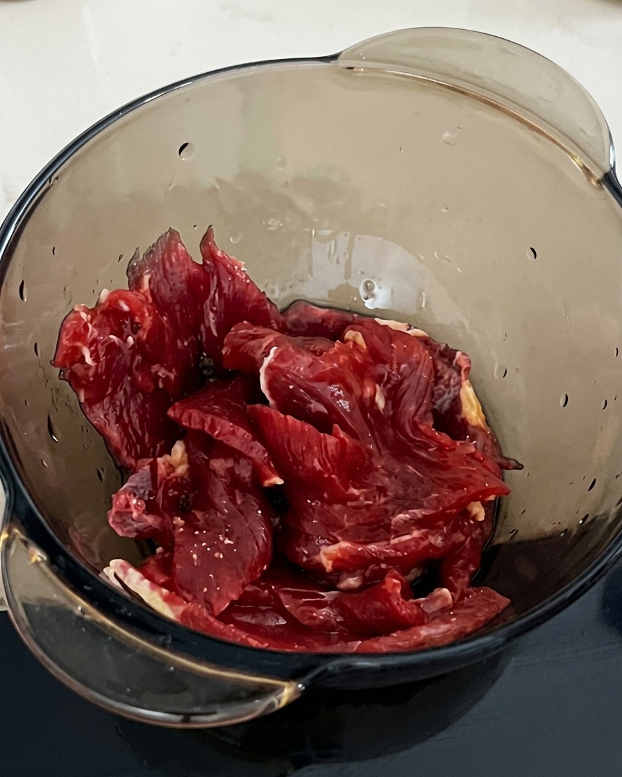 간장 양념된 소고기에 전분을 한 스푼 넣는 모습.