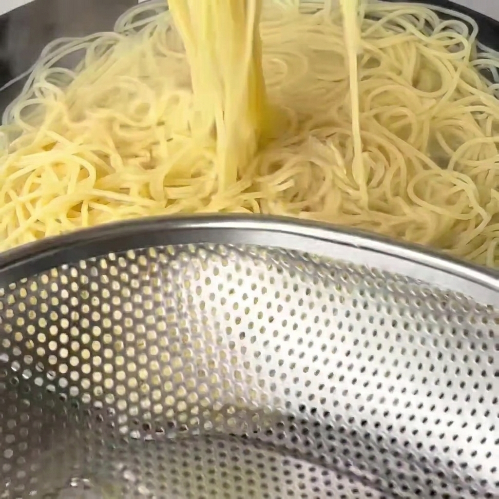 삶아진 면을 젓가락으로 건져내는 모습