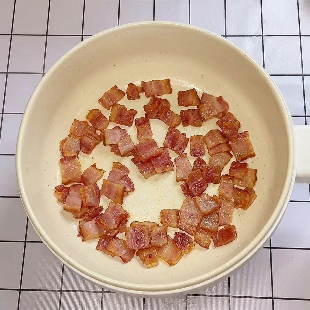 팬에서 노릇하게 익어가는 베이컨.