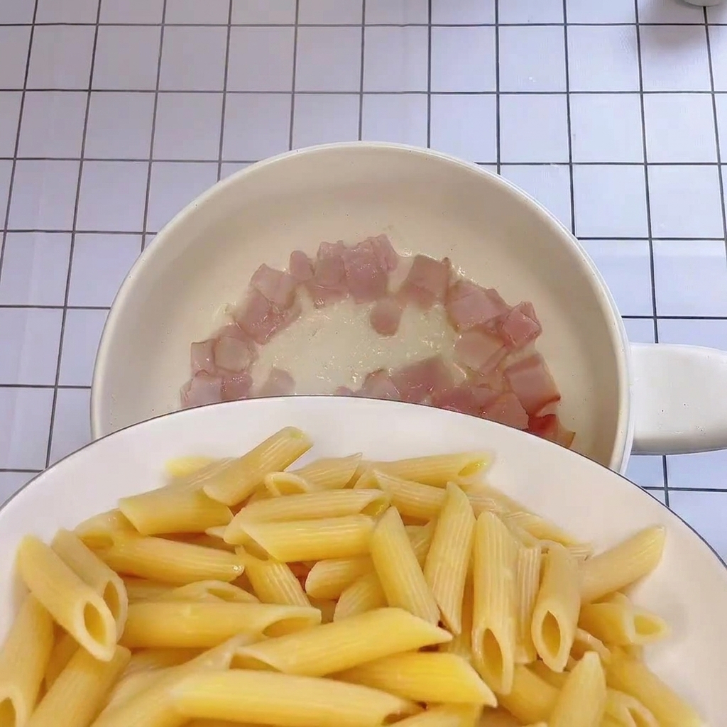 삶은 펜네를 베이컨이 있는 팬으로 옮기는 모습.