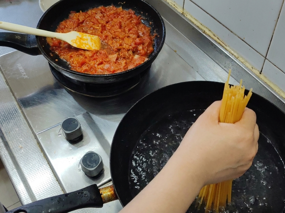 끓는 물에 스파게티 면을 넣는 모습.