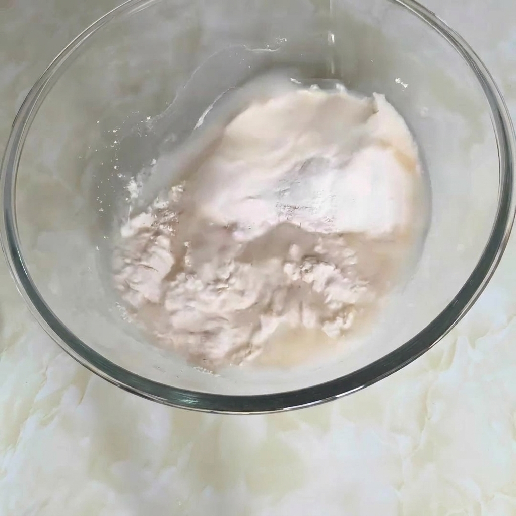 밀가루, 물 등 반죽 재료가 담긴 볼을 젓고 있는 모습.