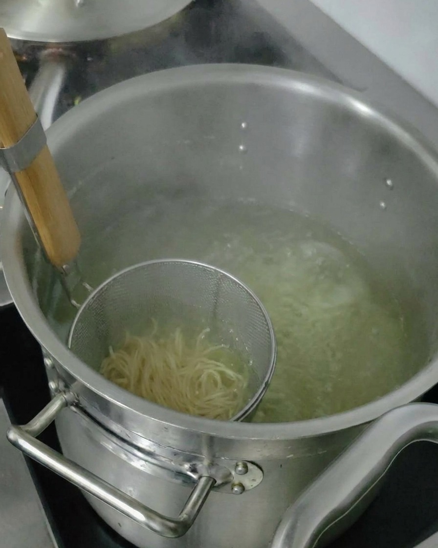삶아진 면의 물기를 털어내고 그릇에 담는 모습