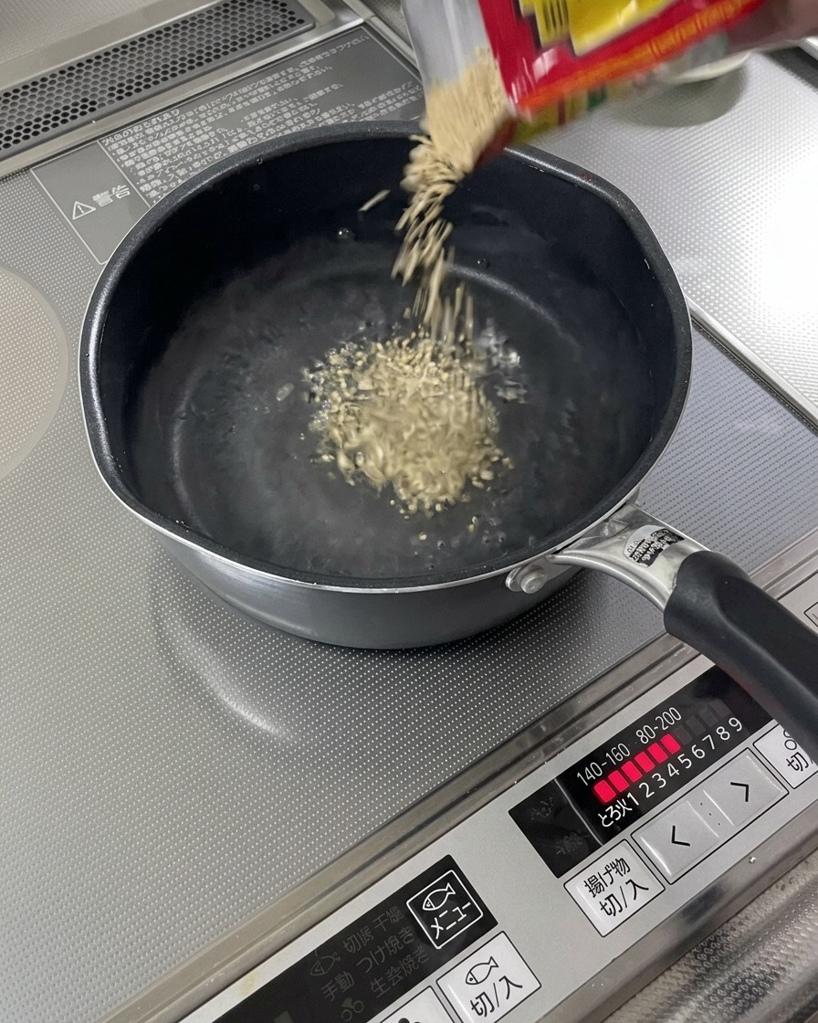 끓고 있는 육수가 담긴 냄비에 구운 참깨가 떨어지는 모습.