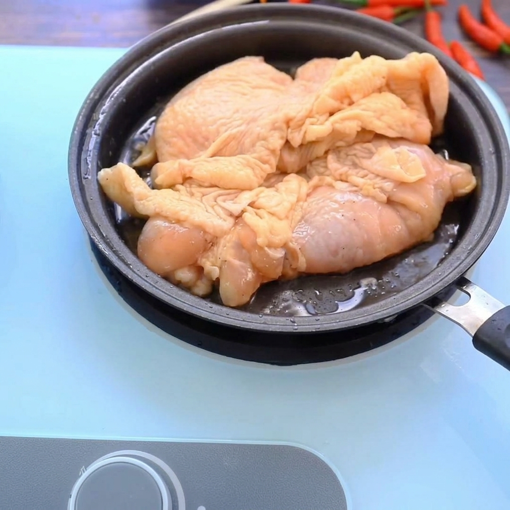 팬 위에서 황금빛으로 맛있게 구워지는 닭다리살
