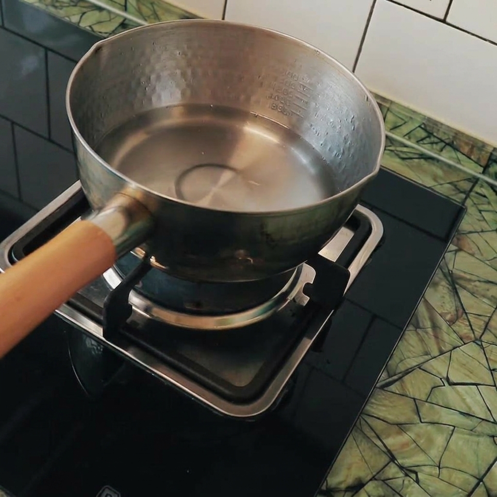 끓는 물이 담긴 냄비에 깍둑썰기한 두부를 넣는 모습.