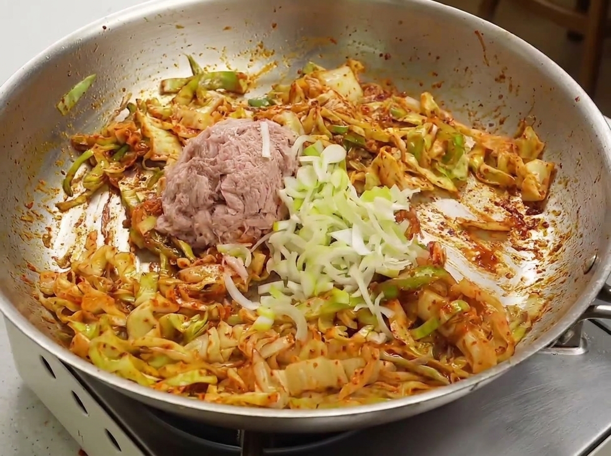 볶음 요리에 참치와 대파를 올리는 모습.
