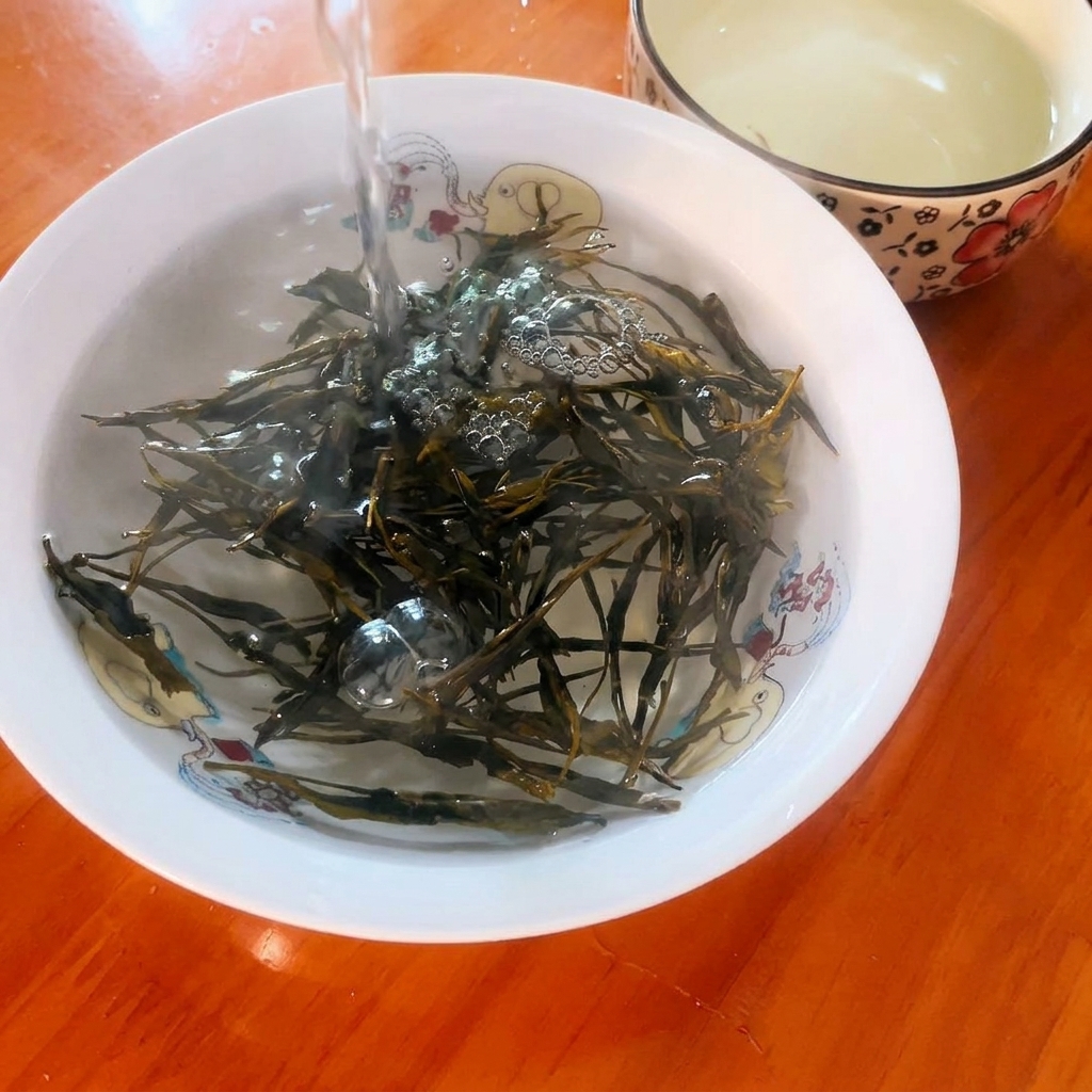 작은 그릇에 담긴 녹차 잎 위로 끓는 물을 붓는 모습.