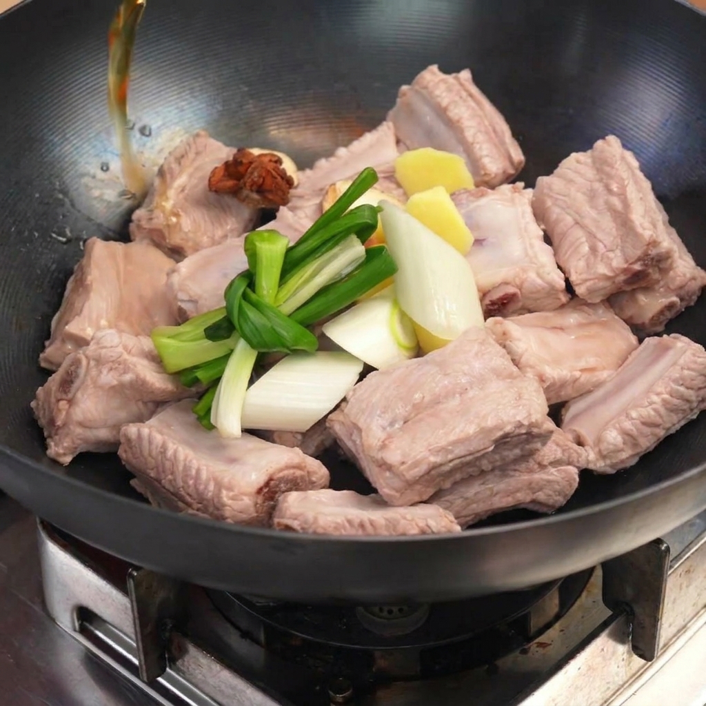 데쳐낸 갈비 위에 대파, 생강, 팔각을 올리고 물을 붓는 모습
