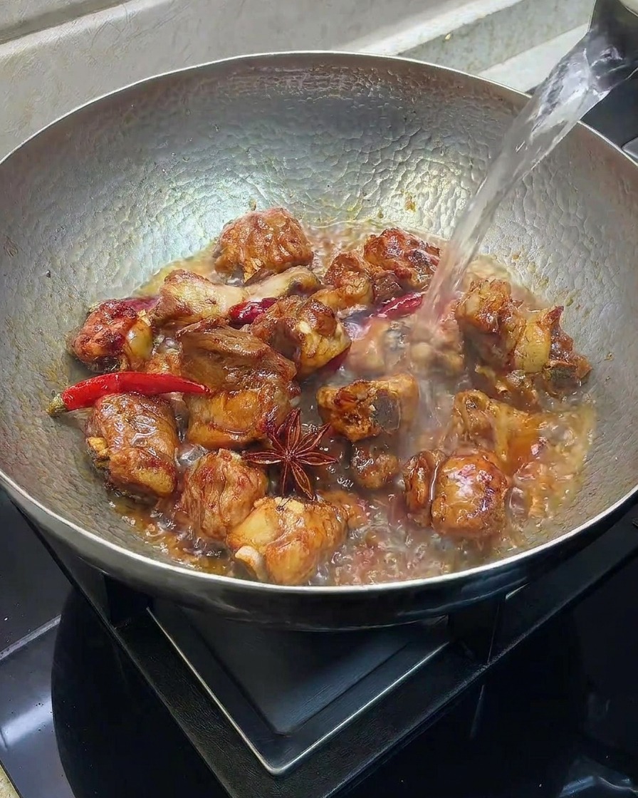 갈비가 담긴 웍에 뜨거운 물을 붓는 모습.