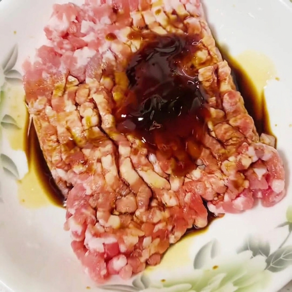 날고기 반죽 위에 치킨 스톡 가루를 뿌리는 모습.
