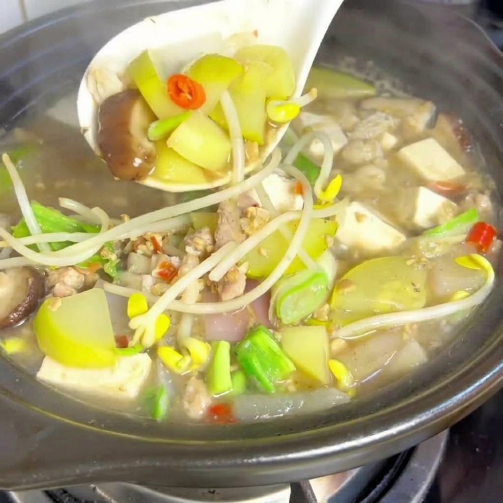 끓는 찌개에 조심스럽게 두부를 넣는 모습.