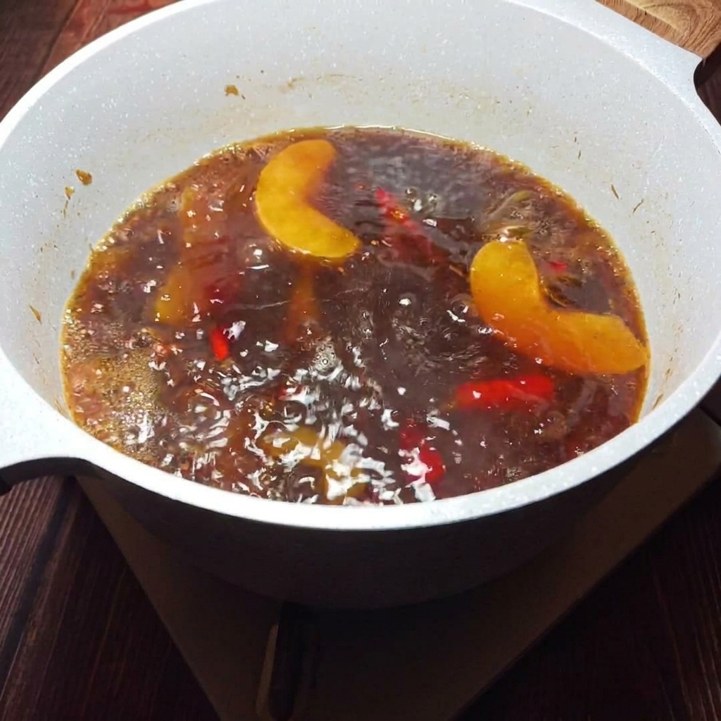 황금빛 육수를 고운 체에 걸러내어 맑은 국물만 따로 받는 모습.