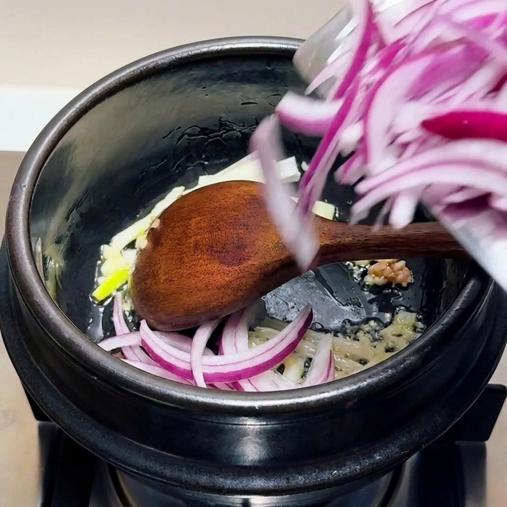 다진 마늘, 양파, 쪽파를 볶는 모습.
