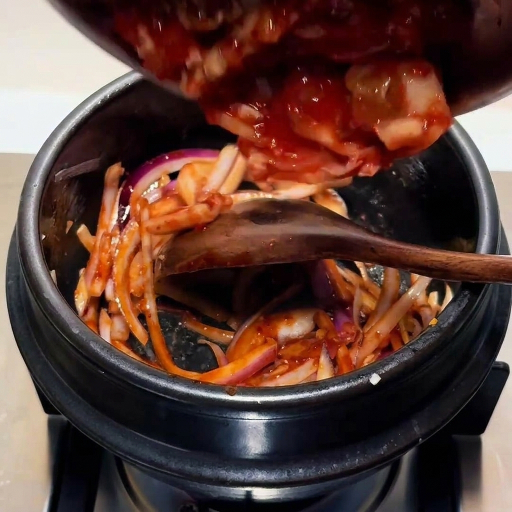 썰어둔 김치를 넣고 볶는 모습.