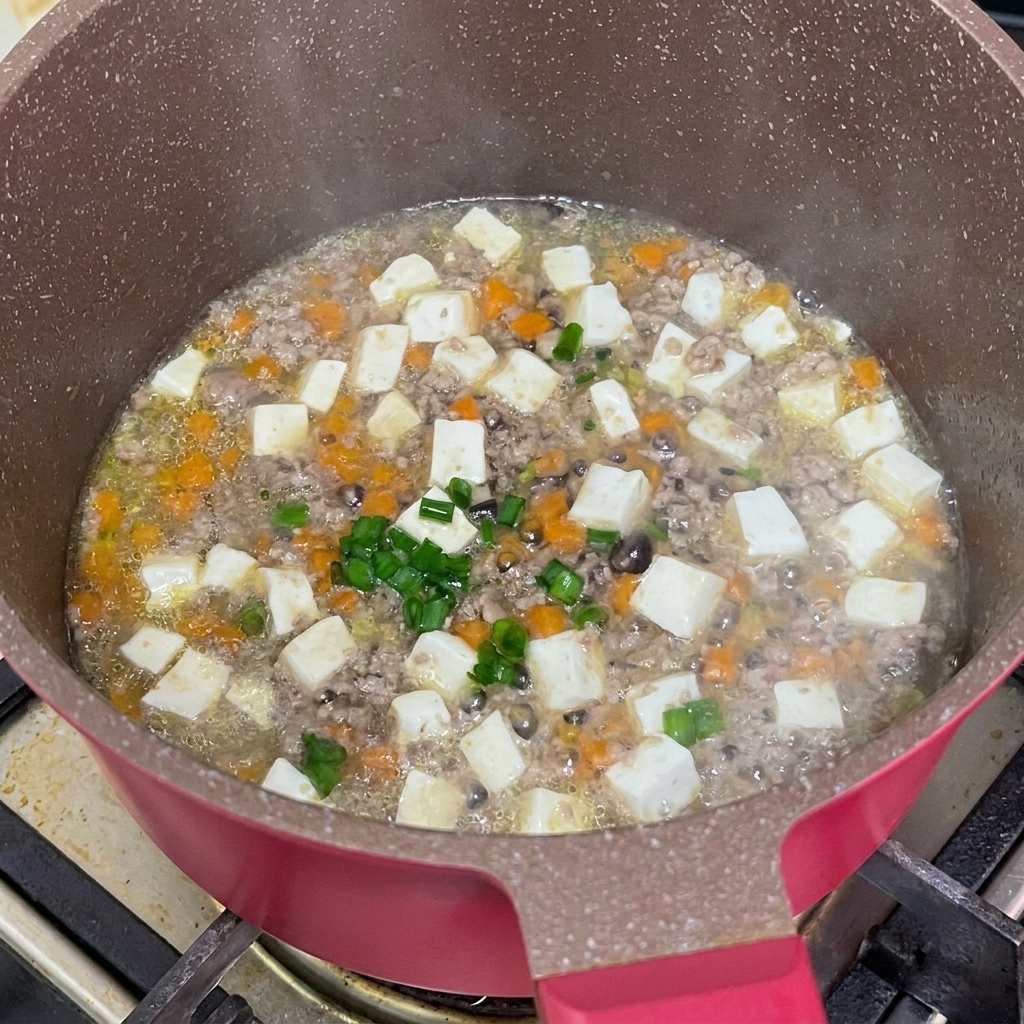 완성된 조림 위에 다진 대파를 뿌리는 모습.