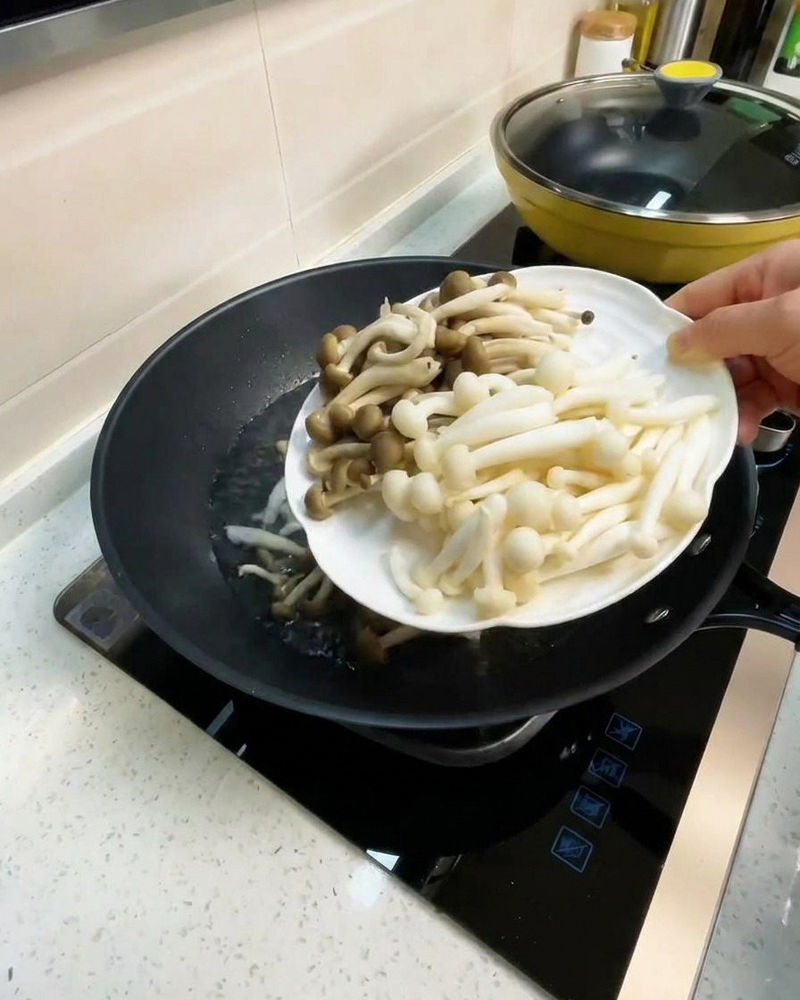 끓는 육수에 백만송이 버섯과 만가닥 버섯을 넣는 모습.