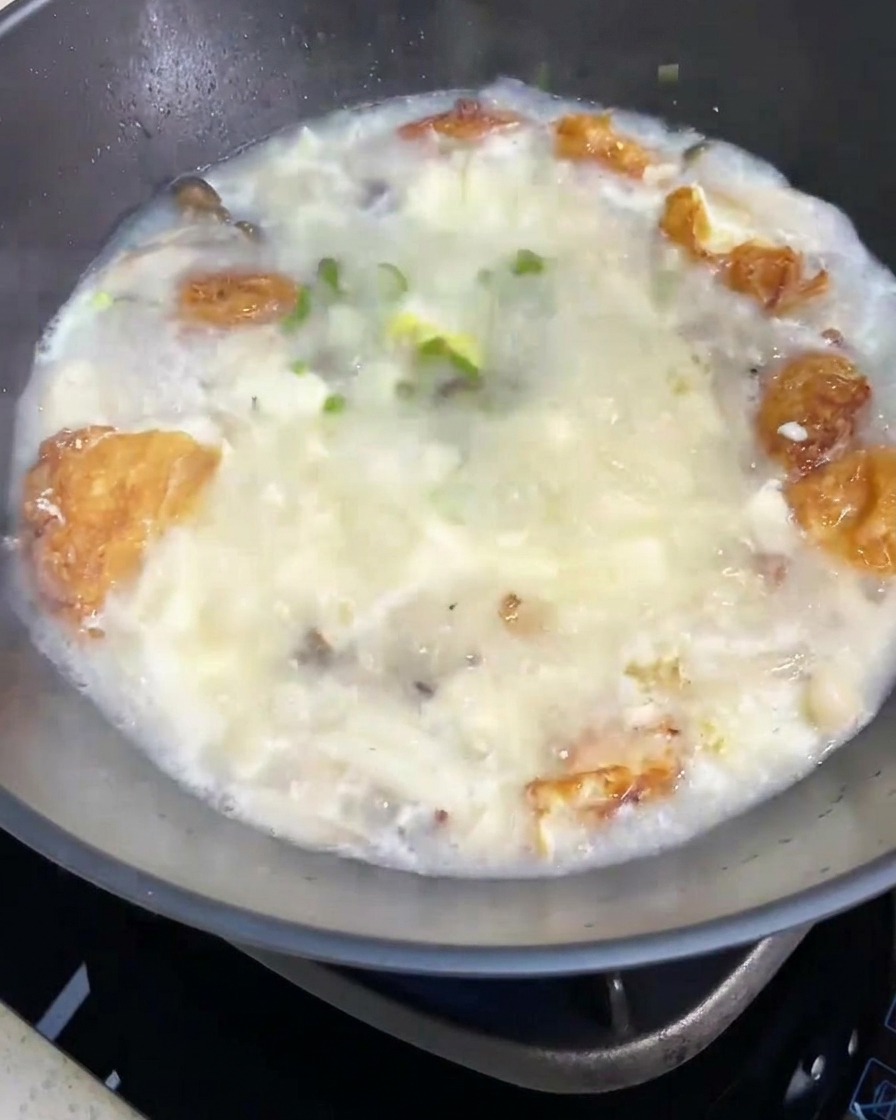 완성된 버섯 두부탕 위에 신선한 대파를 뿌리는 모습.