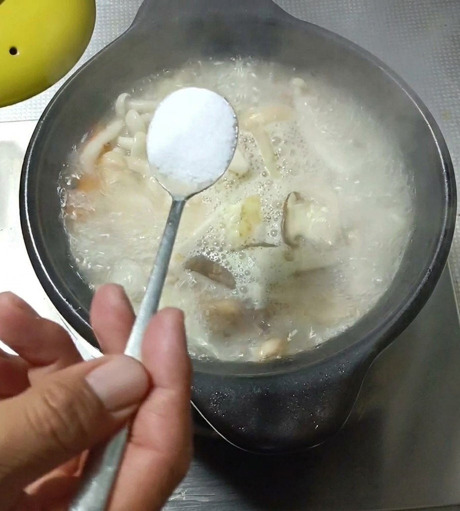 끓고 있는 버섯 계란국에 양념을 추가하는 모습.