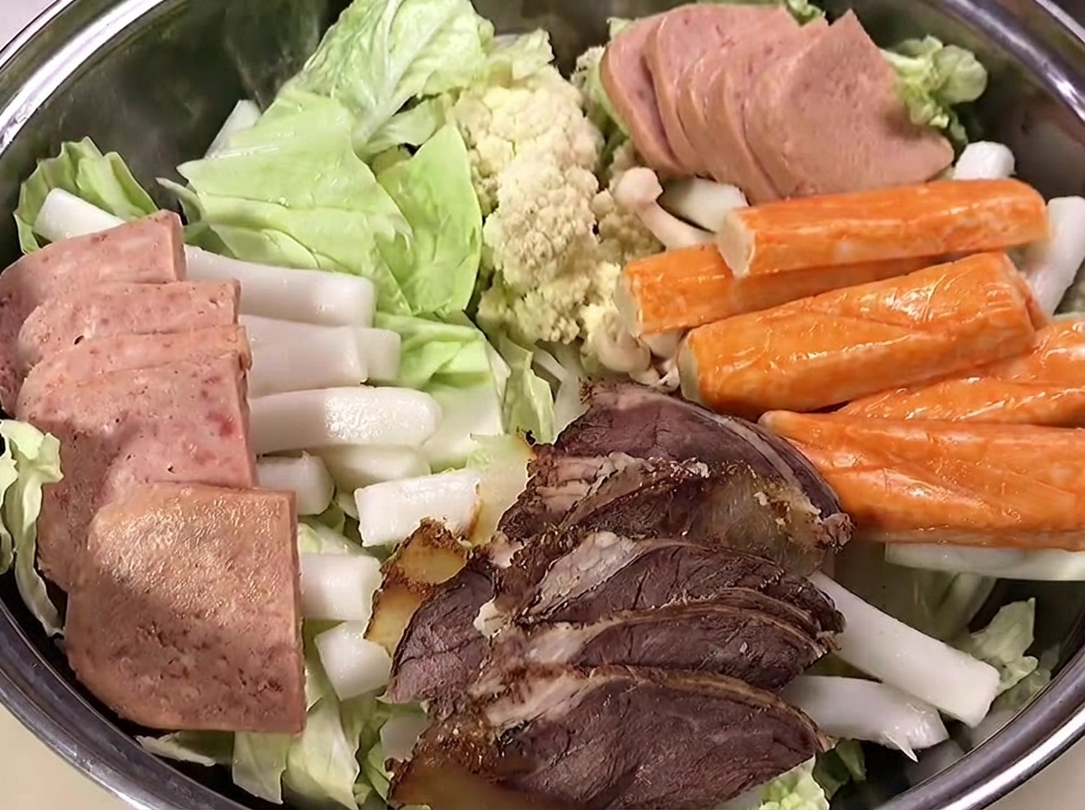 어묵과 새우를 재료 위에 올리는 모습