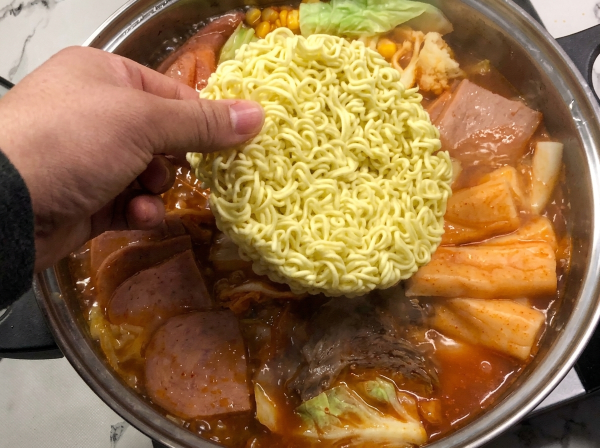 끓는 찌개에 라면 사리를 넣는 모습