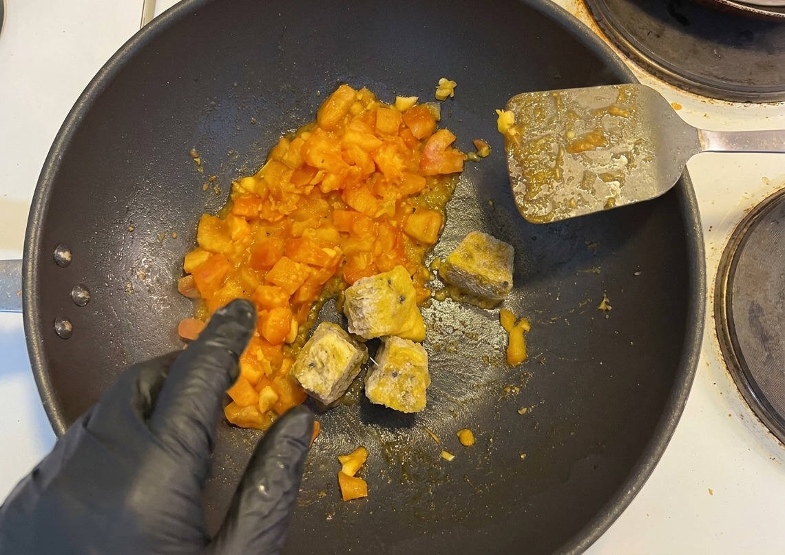토마토를 볶던 팬에 패션프루트 과육과 다진 고추를 넣는 모습.