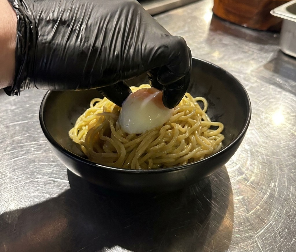 면 위에 온센 타마고를 조심스럽게 올리는 모습.