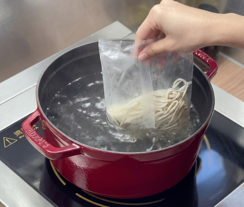 끓는 물에 라멘 면을 넣는 장면