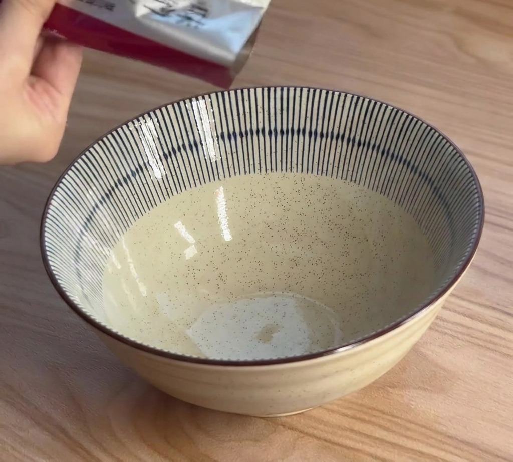 그릇에 미소 라멘 농축액을 짜 넣는 모습