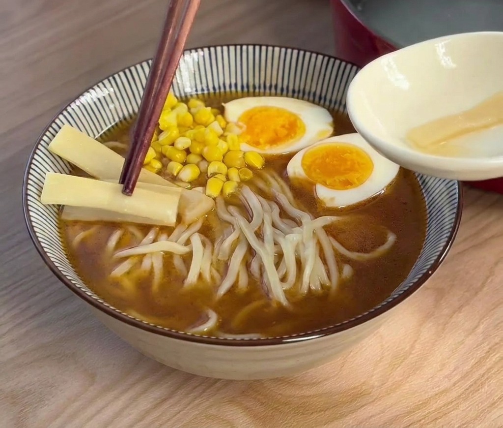 라멘 그릇에 죽순 슬라이스를 올리는 모습