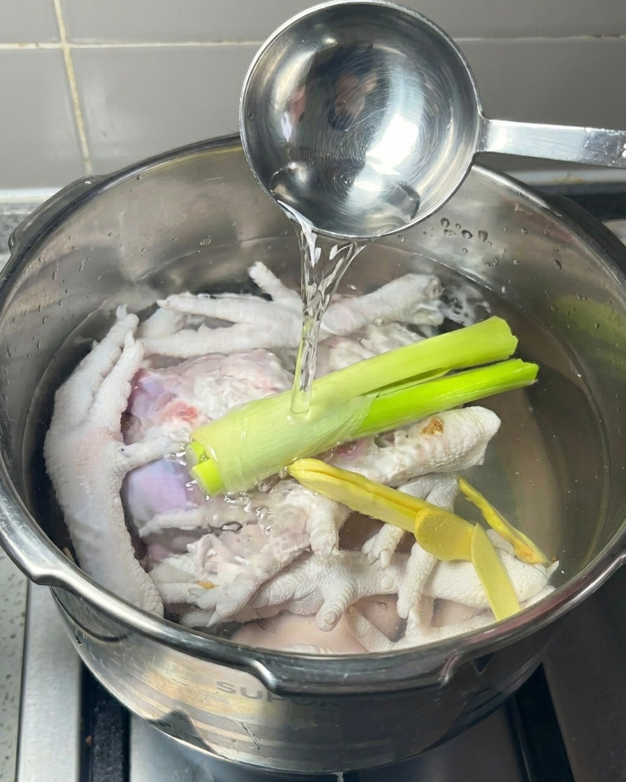 닭발과 채소가 담긴 압력솥에 국자로 화이트 와인을 붓는 모습.