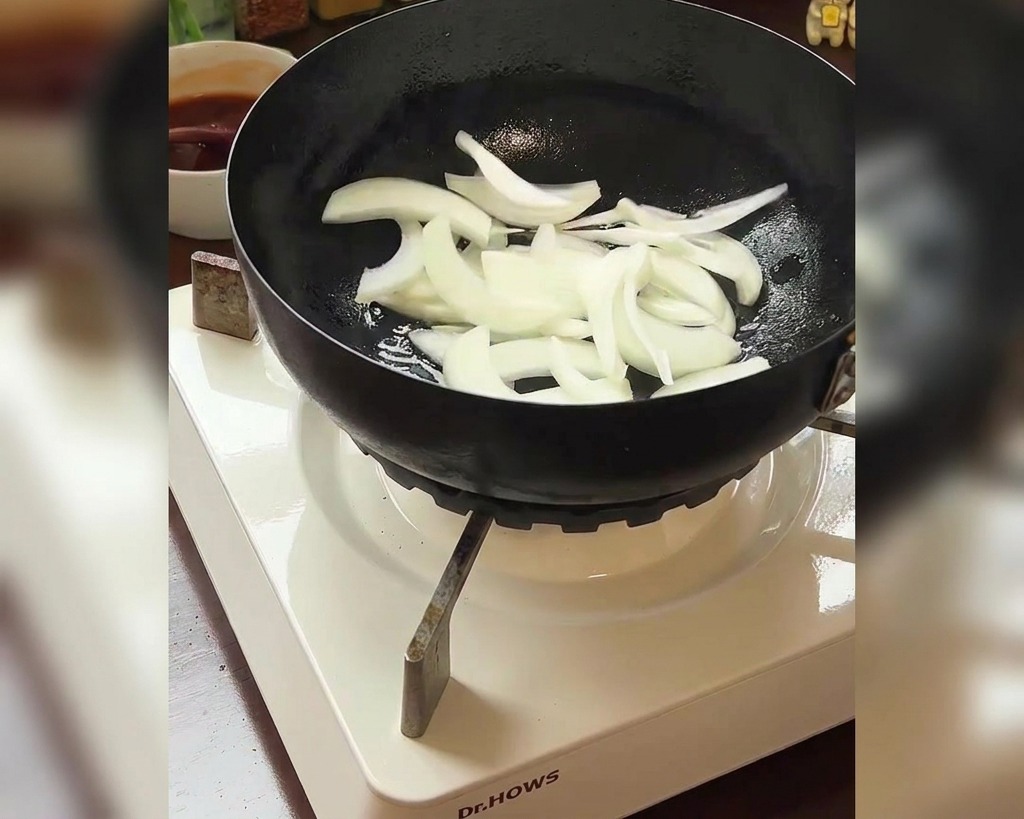 팬에 채 썬 양파를 넣는 모습과 옆에 놓인 신김치 그릇.