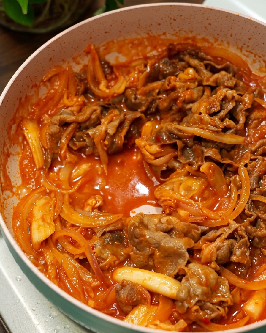 보글보글 끓는 붉은 양념 속에서 맛있게 볶아지는 우삼겹과 양파.