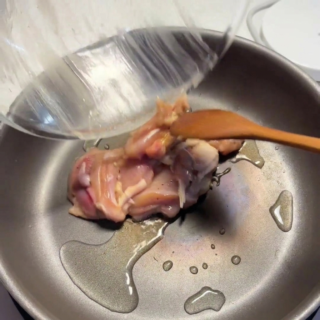 기름을 두른 팬에 밑간한 닭고기를 넣고 노릇하게 익히는 모습.
