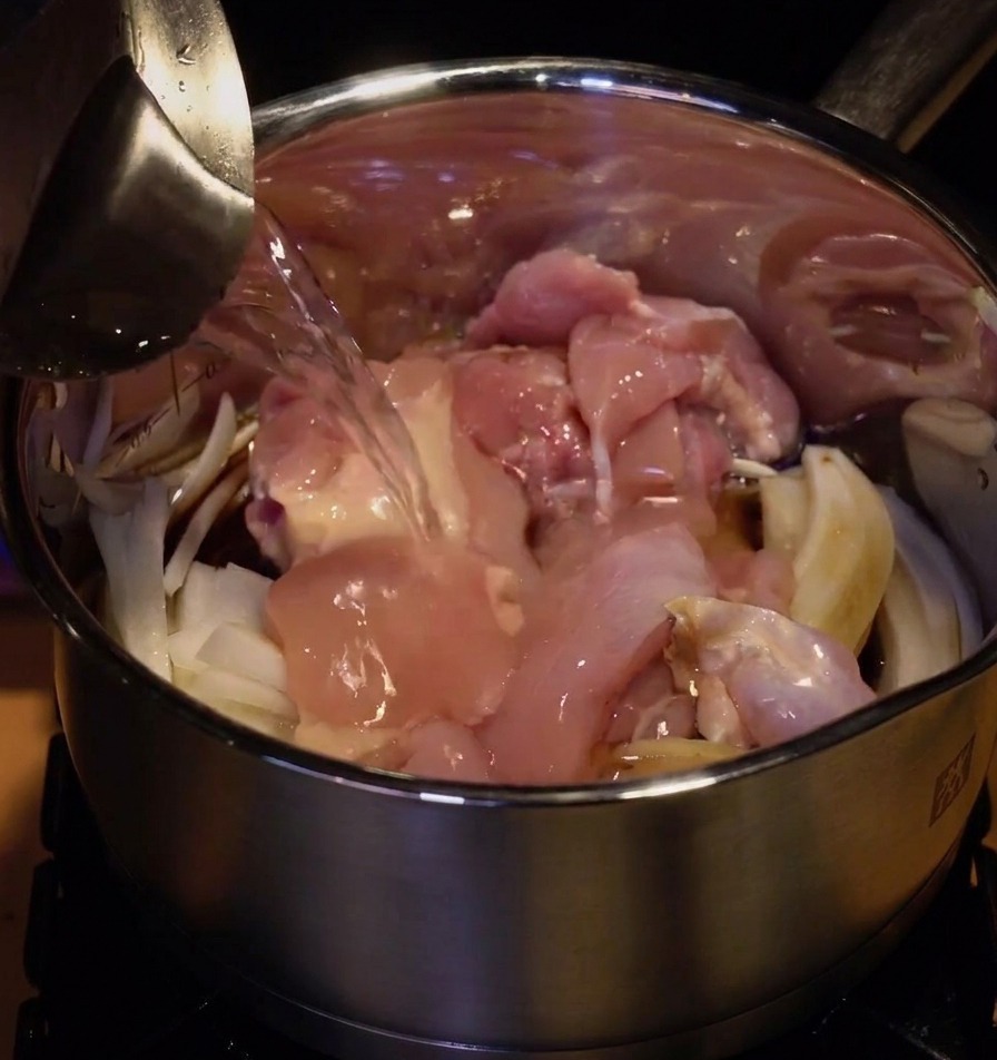 재료가 담긴 냄비에 물을 붓는 모습.