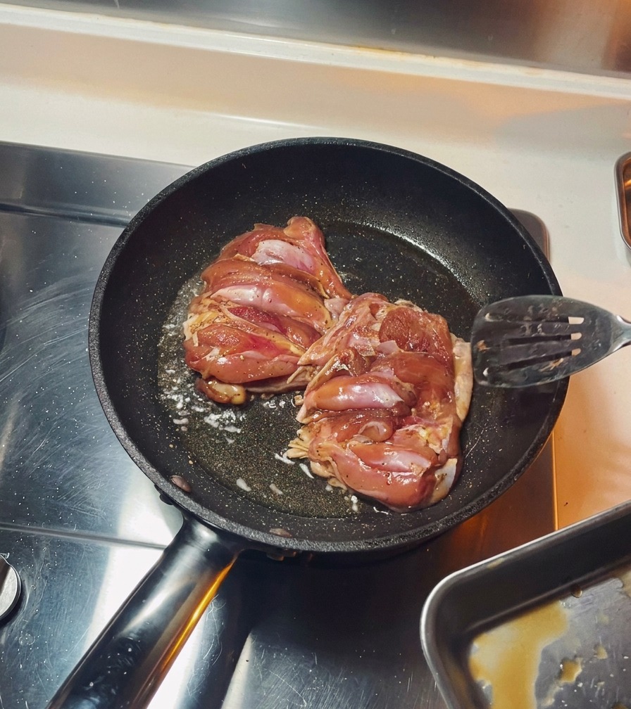팬에서 닭다리살 껍질 쪽을 노릇하게 굽는 모습