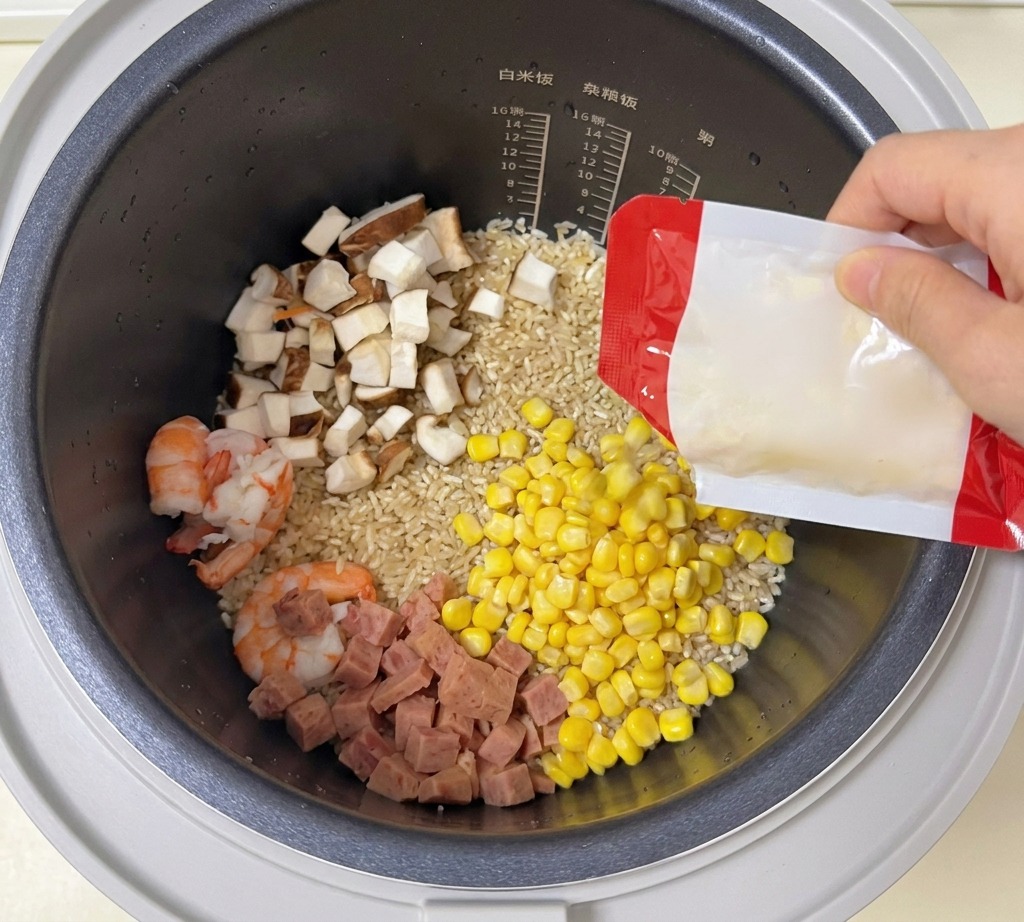 새우, 버섯, 스팸이 담긴 밥솥 안으로 옥수수 알갱이를 붓는 모습.