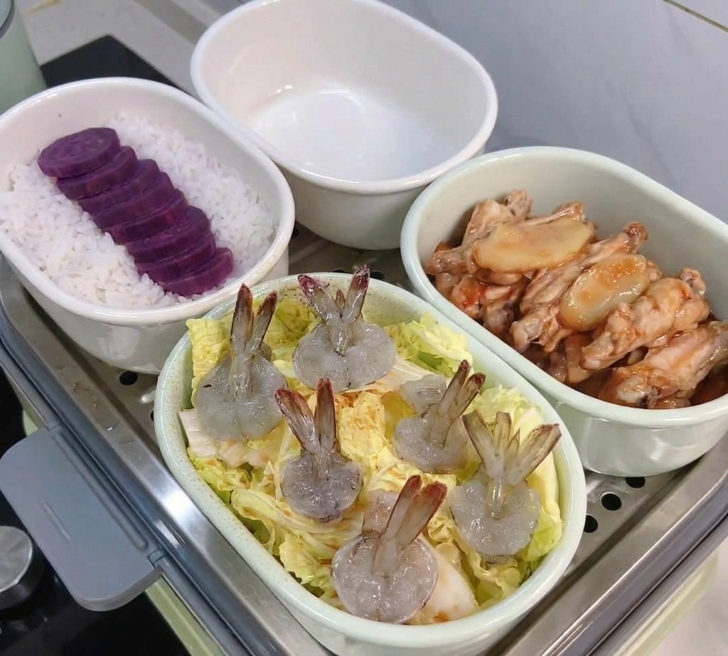 알배기 배추 위에 손질된 칵테일 새우를 올린 찜 요리 접시.