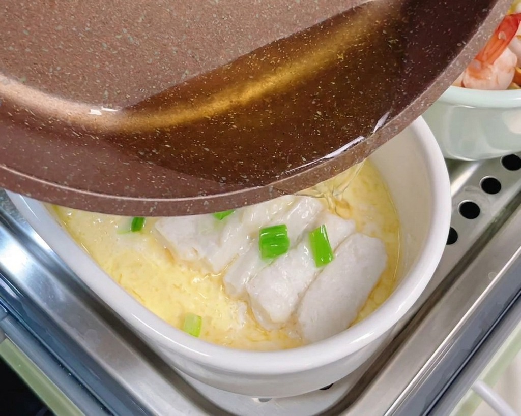 팬에 달군 기름을 쪽파와 대구 달걀찜 위에 부어 향을 깨우는 모습.