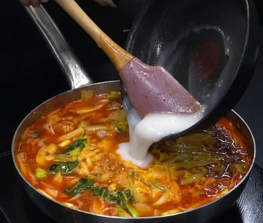 보글보글 끓는 빨간 국물에 미리 준비한 하얀 루 베이스를 붓는 모습