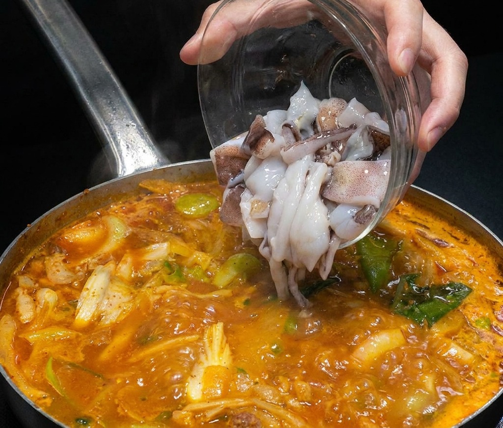 끓는 국물 속에 손질된 생오징어를 넣는 모습