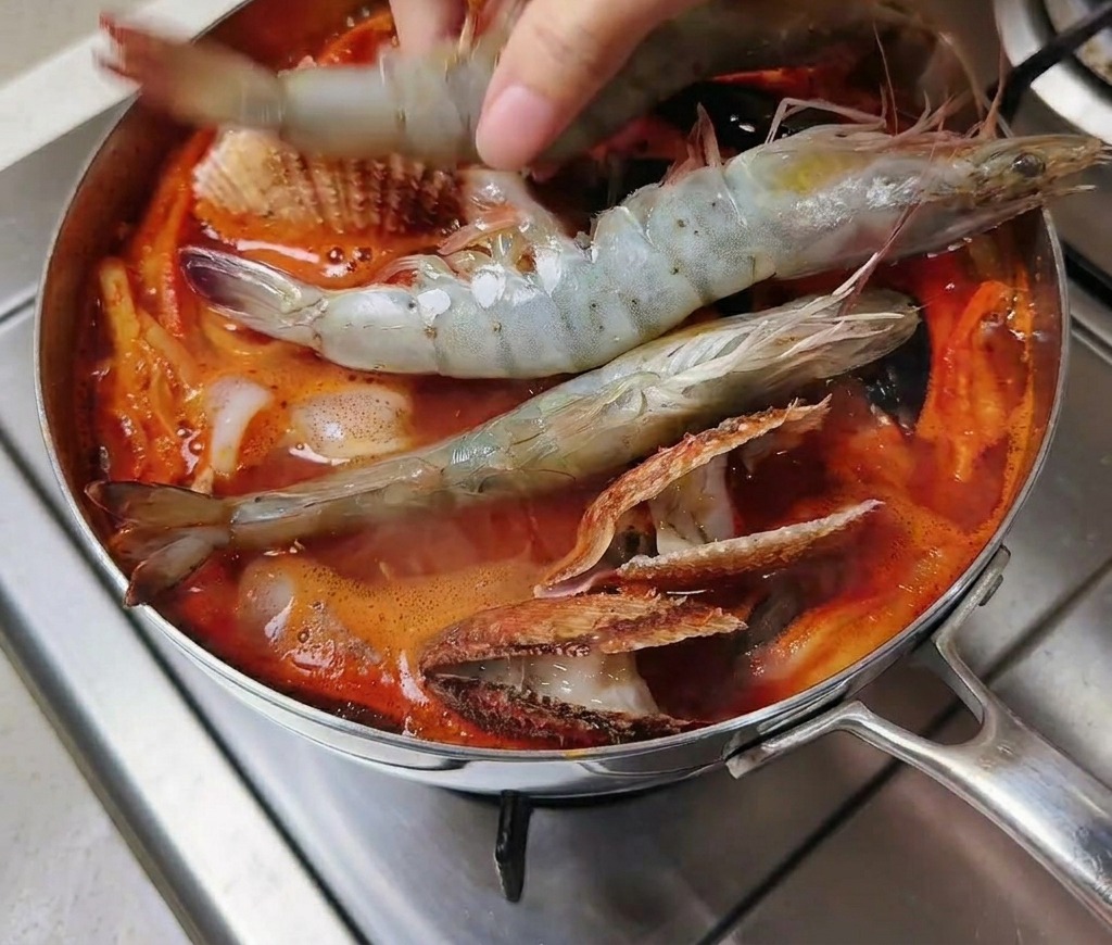 냄비에 큼직한 새우를 넣는 모습