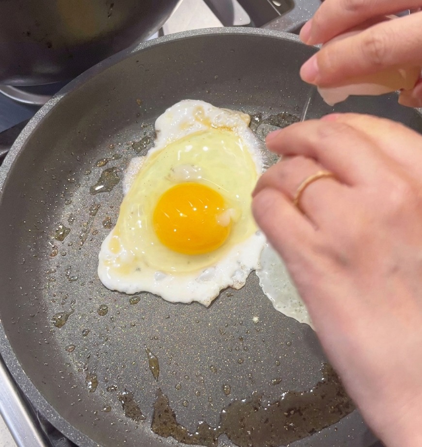 스크램블을 만들기 위해 논스틱 팬에 계란을 깨트려 넣는 모습.